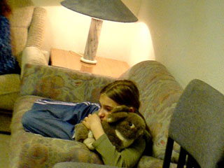 Kinde mit Stofftier im Arm auf dem Sofa; Rechte: bzd. pr-team