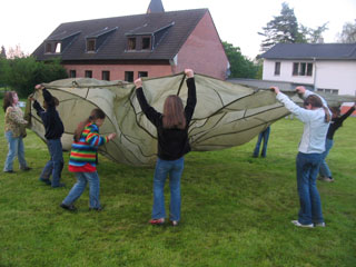 Kinder spielen mit Fallschirm