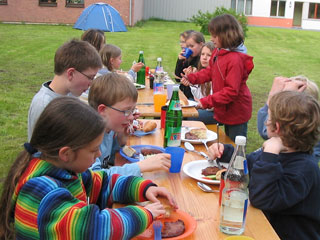 Kinder essen im Pfarrgarten