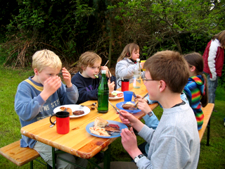 Kinder beim Essen im Pfarrgarten