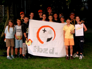 Gruppenfoto: Kinder und Betreuer mit bzd.-Logo 'BERRY' als Fahne; Rechte: bzd. pr-team